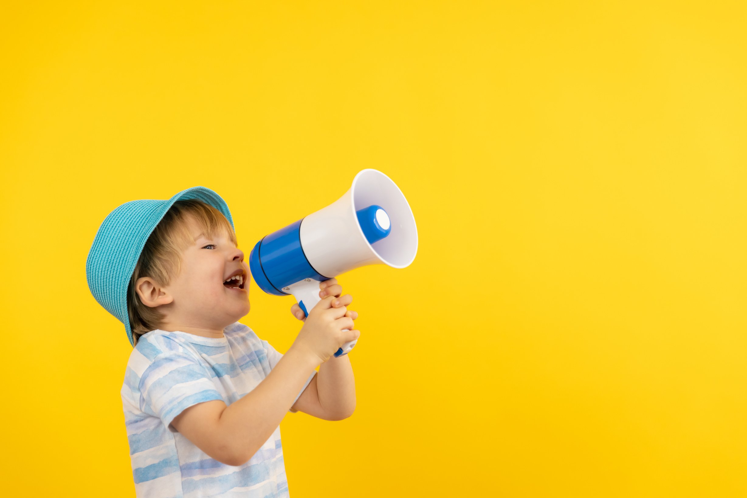 Kid with Loudspeaker on Yellow Background